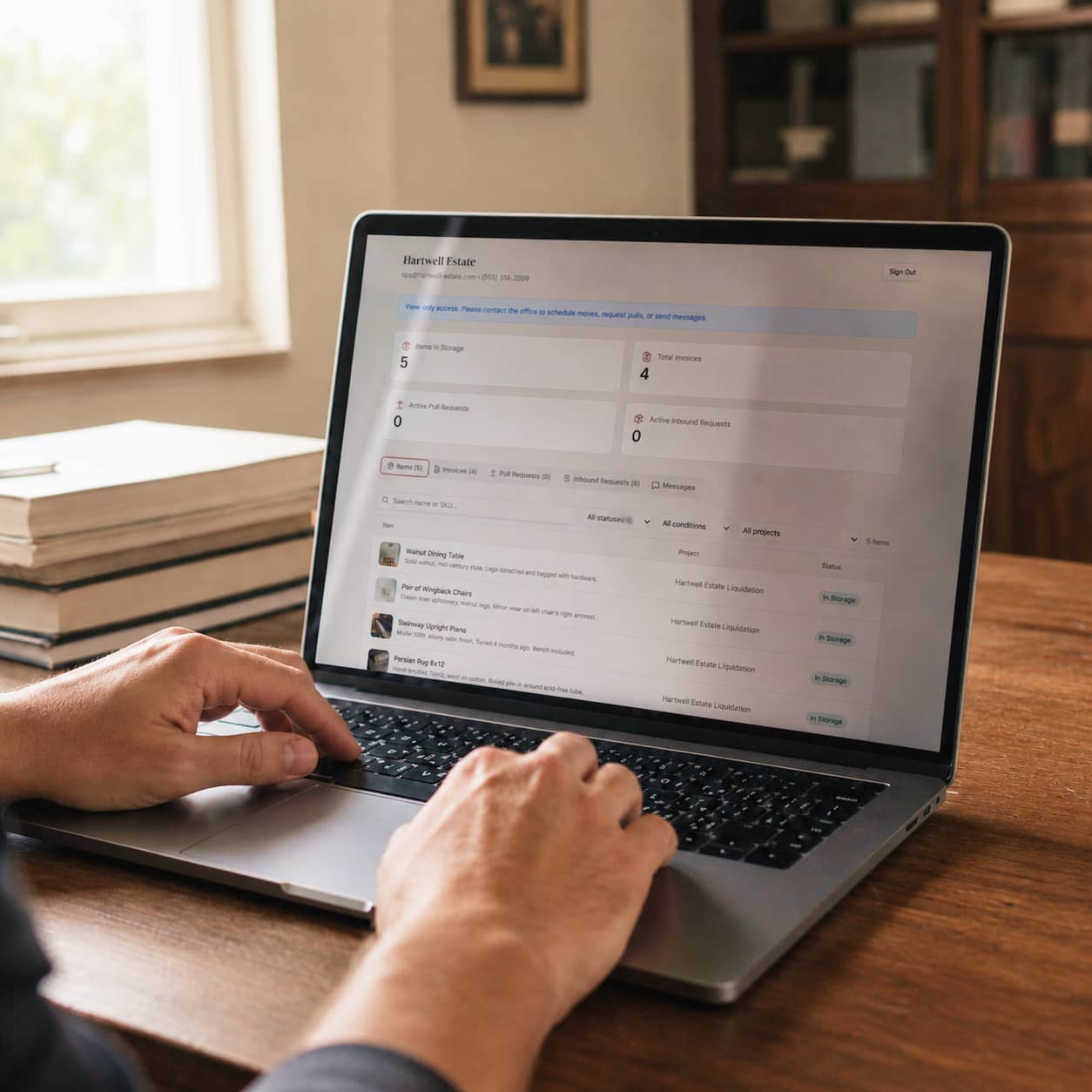 A client browsing their stored collection on a laptop in a warm home office